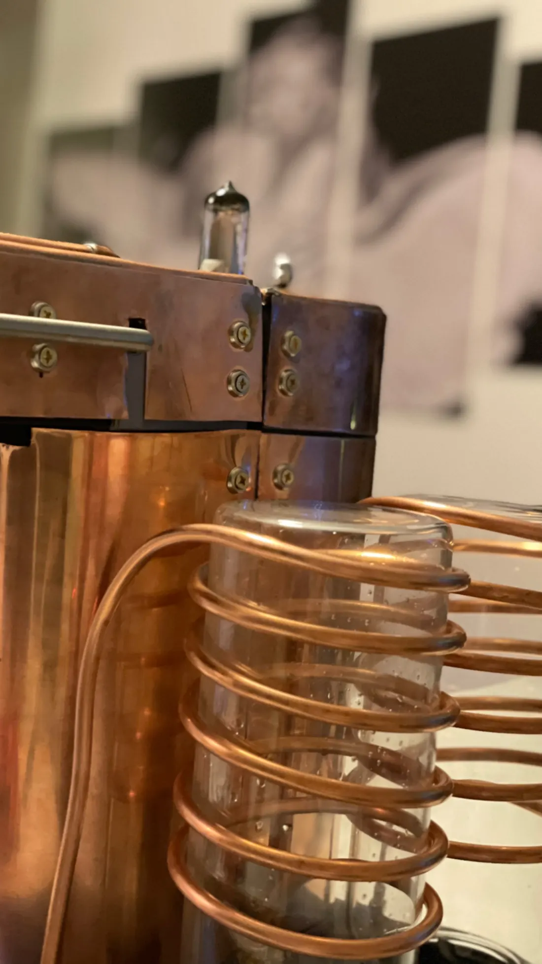 Copper tubing coiled around a glass reservoir on the side of the machine