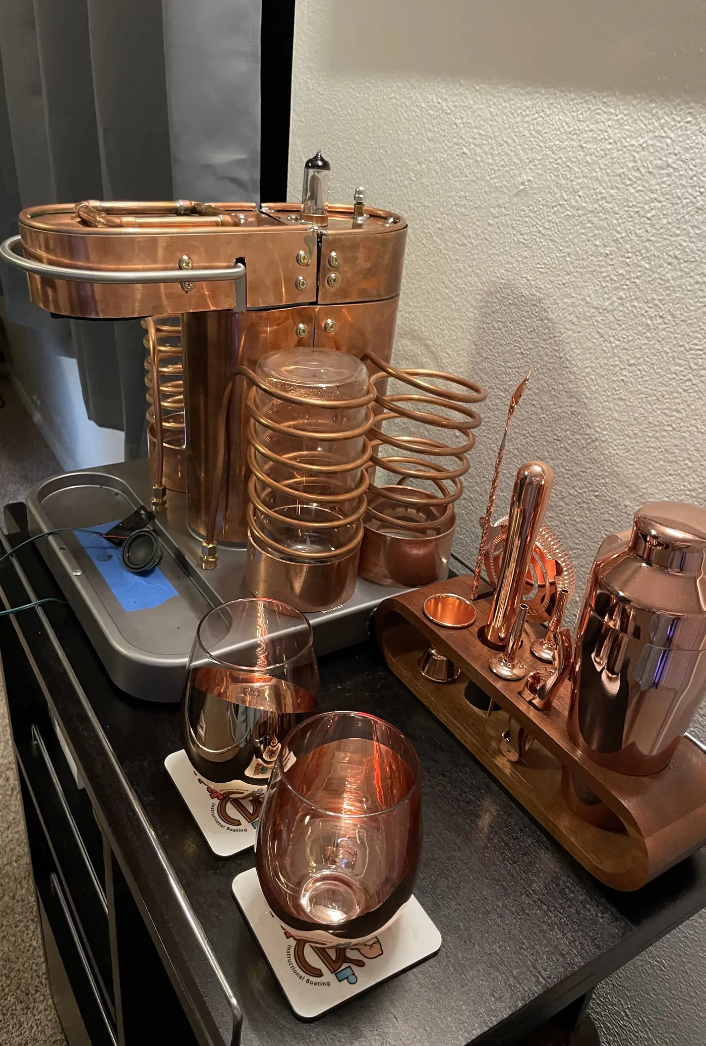 The machine in copper with coils and cradles fitted, beside a copper shaker set