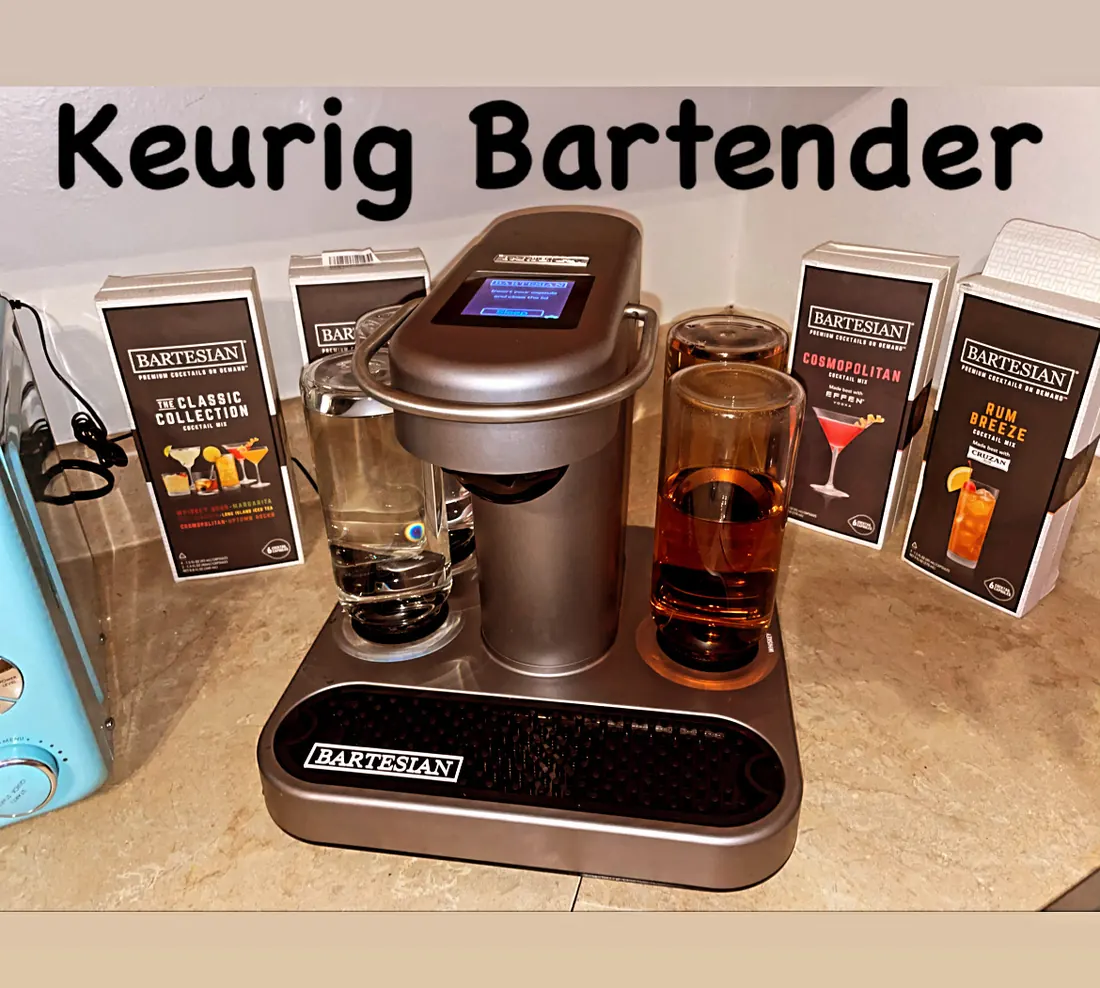 A stock Bartesian cocktail machine on a kitchen counter, with a hand-lettered sign reading Keurig Bartender