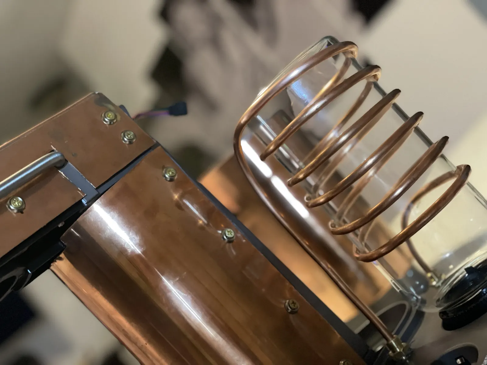 Copper tubing coiled by hand around a glass reservoir