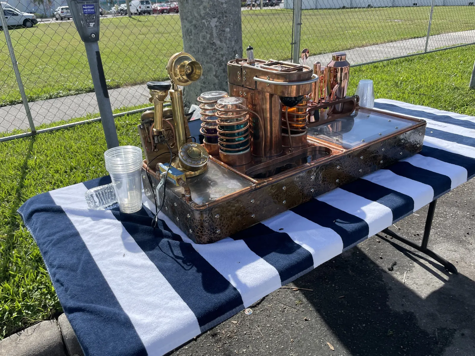 The machine outdoors on a folding table with a striped cloth