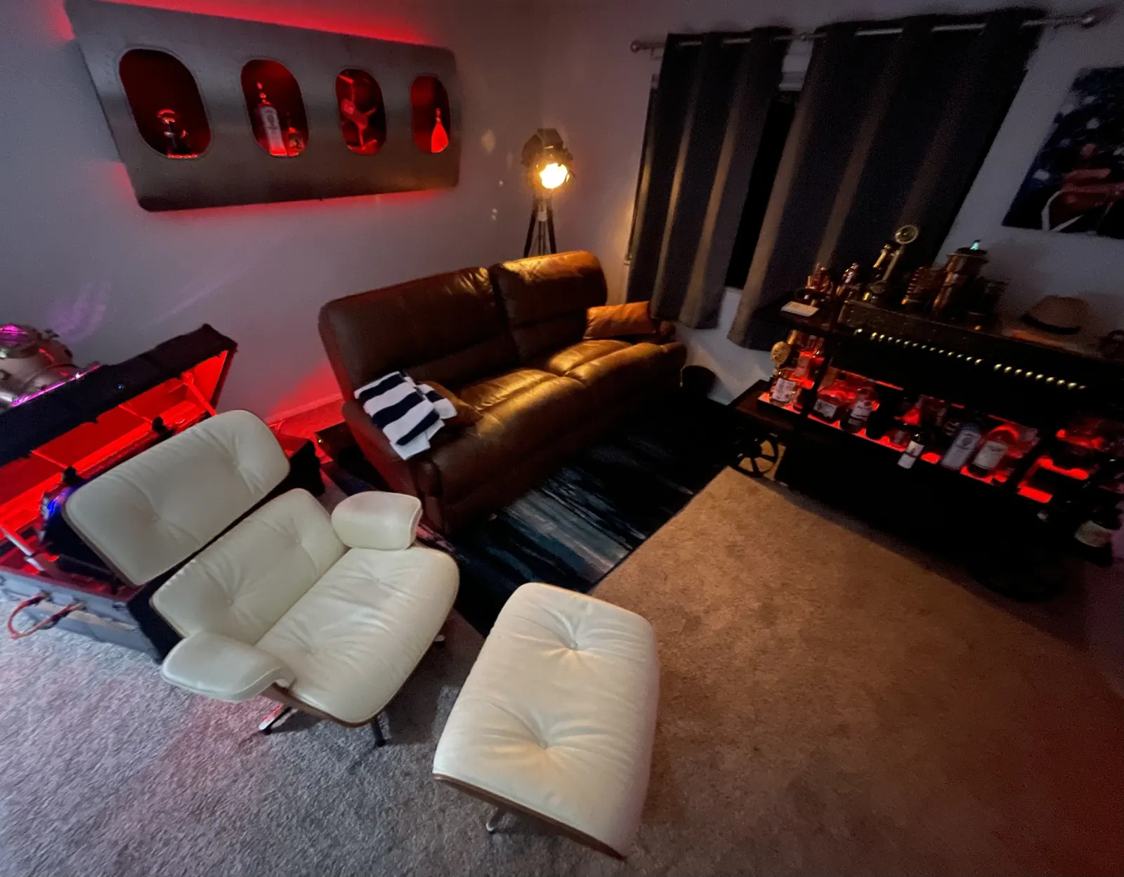 The lounge room: leather chairs, red lighting, the cart bar