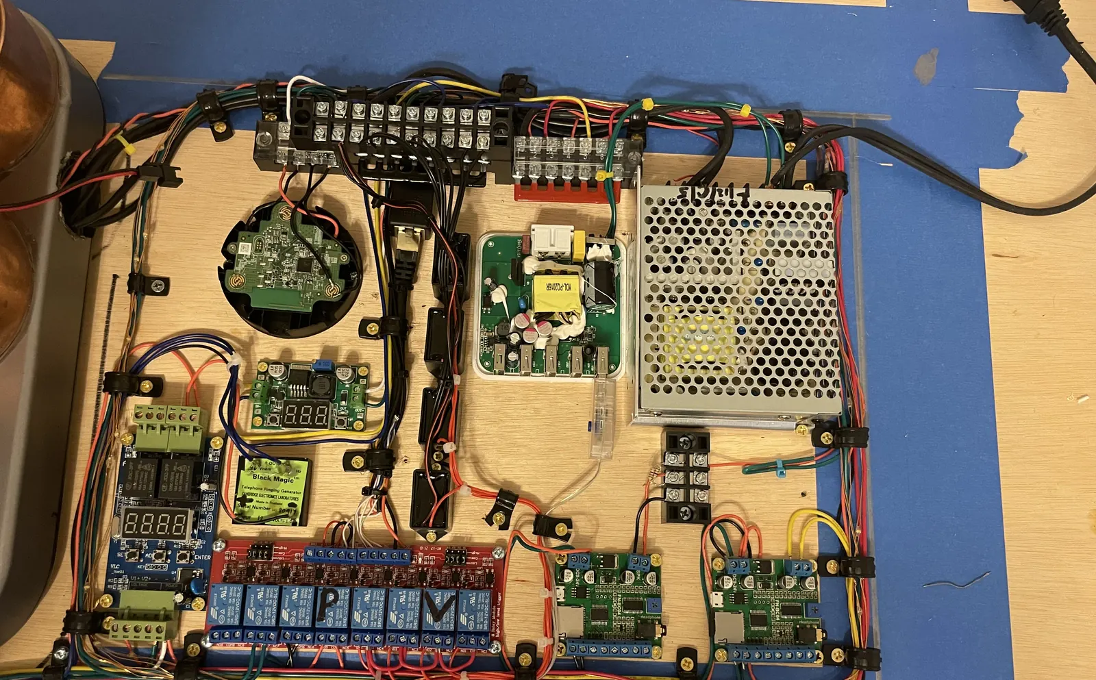 The control board laid out on a workbench: relay board, timers, power supply and wiring, ringed with small lights